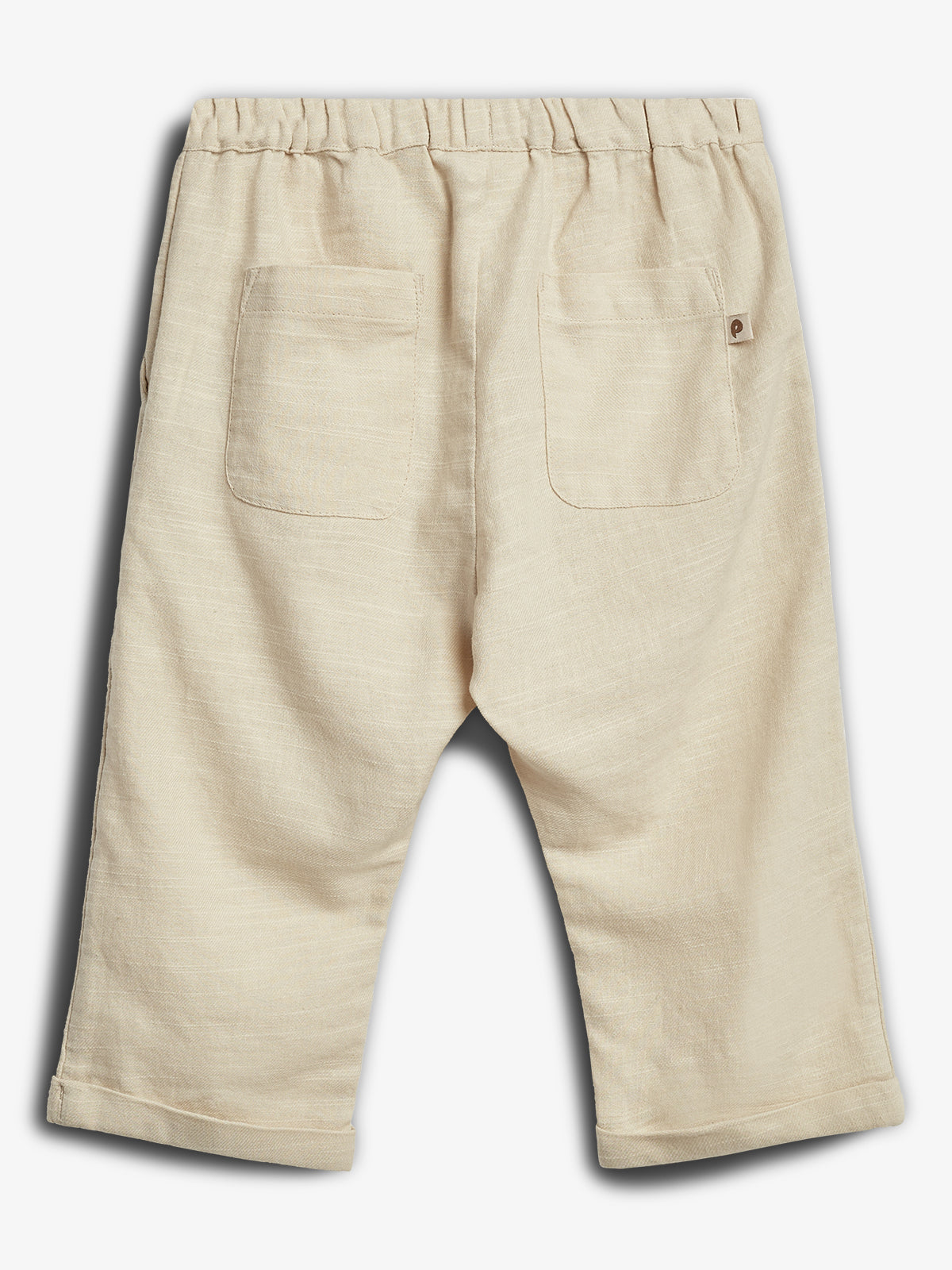 Beige Kinderhose mit elastischem Bund und zwei Gesäßtaschen ohne sichtbare Aktion, auf weißem Hintergrund platziert. Das Material wirkt leicht und strukturiert.