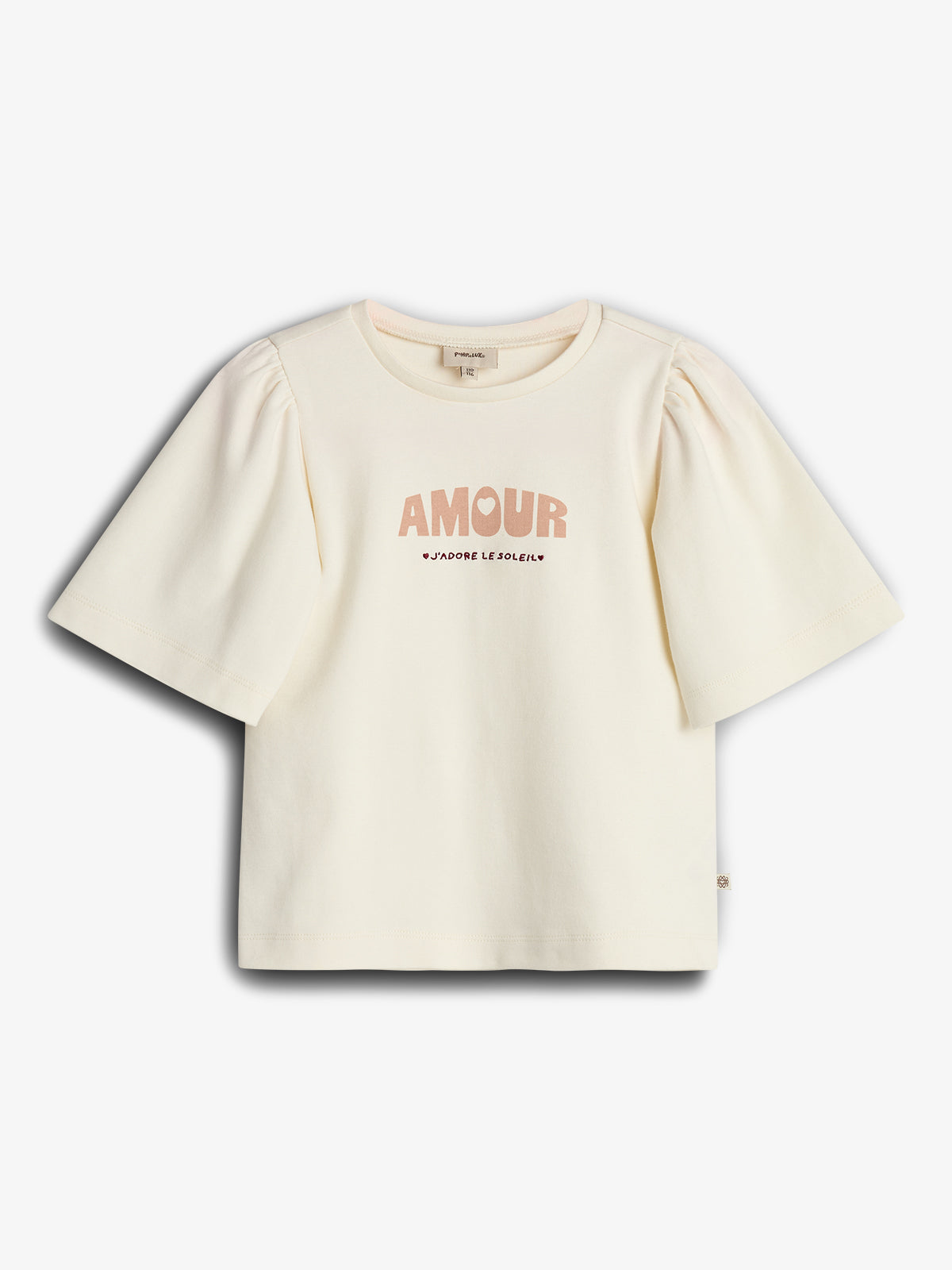 Ein cremefarbenes T-Shirt zeigt in der Mitte den Text "AMOUR J'ADORE LE SOLEIL". Es hat kurze, leicht puffige Ärmel und befindet sich vor weißem Hintergrund.