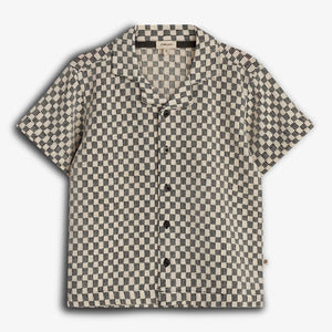 Short-sleeved, button-up shirt featuring a black and beige checkered pattern, displayed against a plain white background. The shirt has a pointed collar and the label "Pine & Lake."