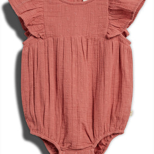A pink baby romper with ruffled sleeves, featuring small embroidered patterns, lies flat against a white background. It has buttons at the bottom for fastening and a visible inner label.