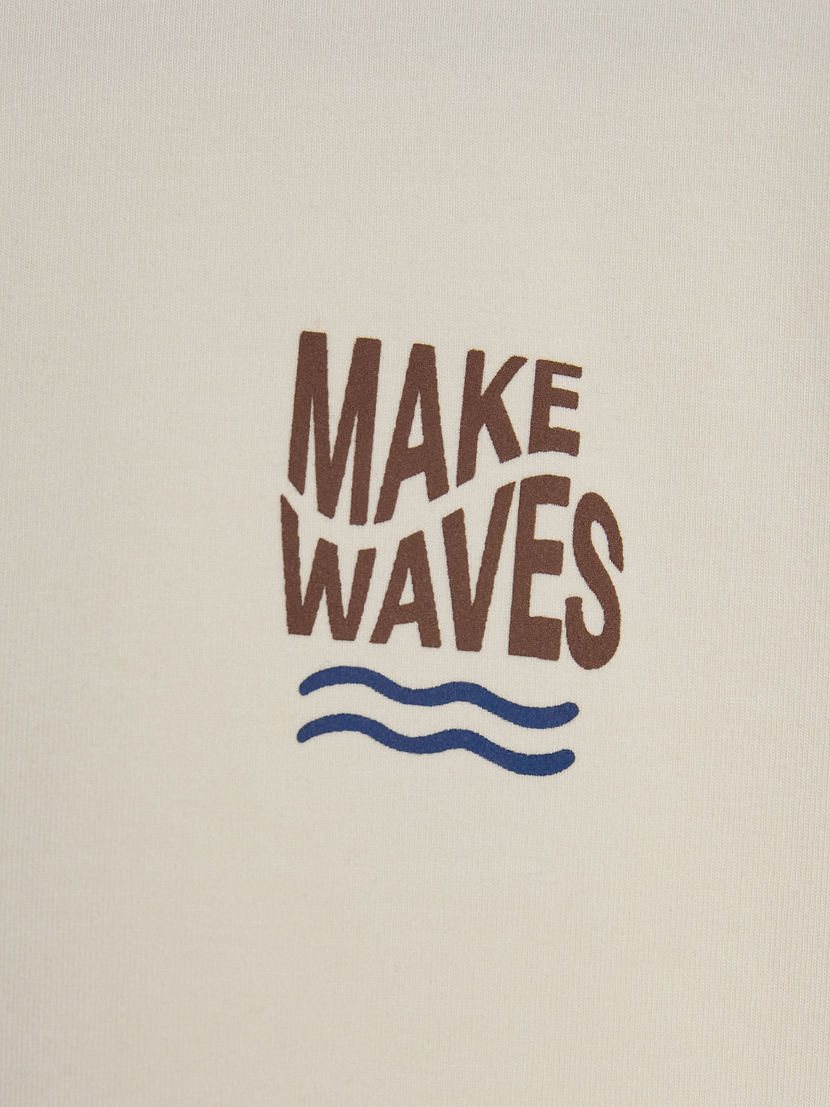 Text in braunen Großbuchstaben "MAKE WAVES" über zwei blauen, geschwungenen Linien auf einem beigefarbenen Hintergrund; symbolisiert Wellen in einer minimalistischen, maritimen Darstellung.