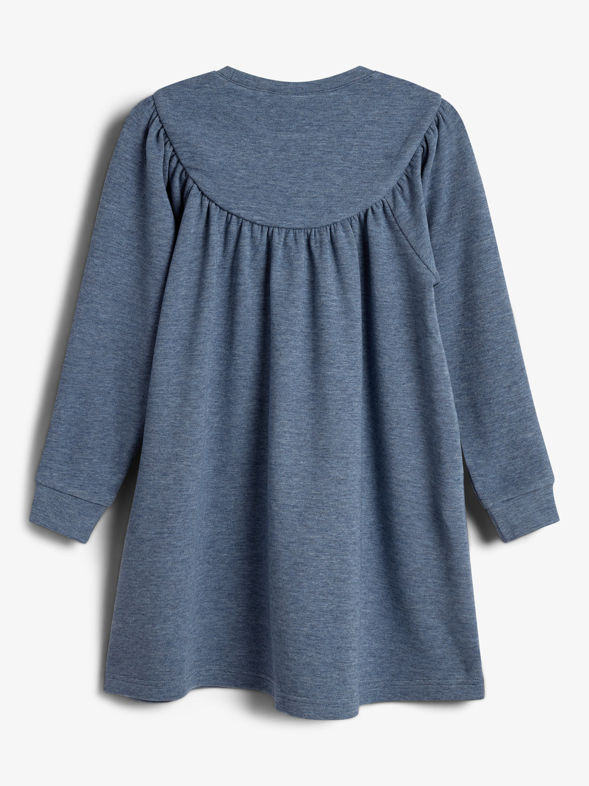 Ein blaues, langärmliges Kleid hängt locker in einem neutralen Raum. Das Kleid hat einen weichen, gerafften Stoff am Rücken und Schultern, ohne erkennbare Abzeichen oder Muster.