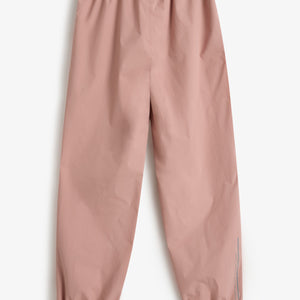 Eine rosa Hose liegt flach auf einem weißen Hintergrund. Sie hat einen elastischen Bund und elastische Beinabschlüsse. Text auf dem Bein: "Polarn O. Pyret".