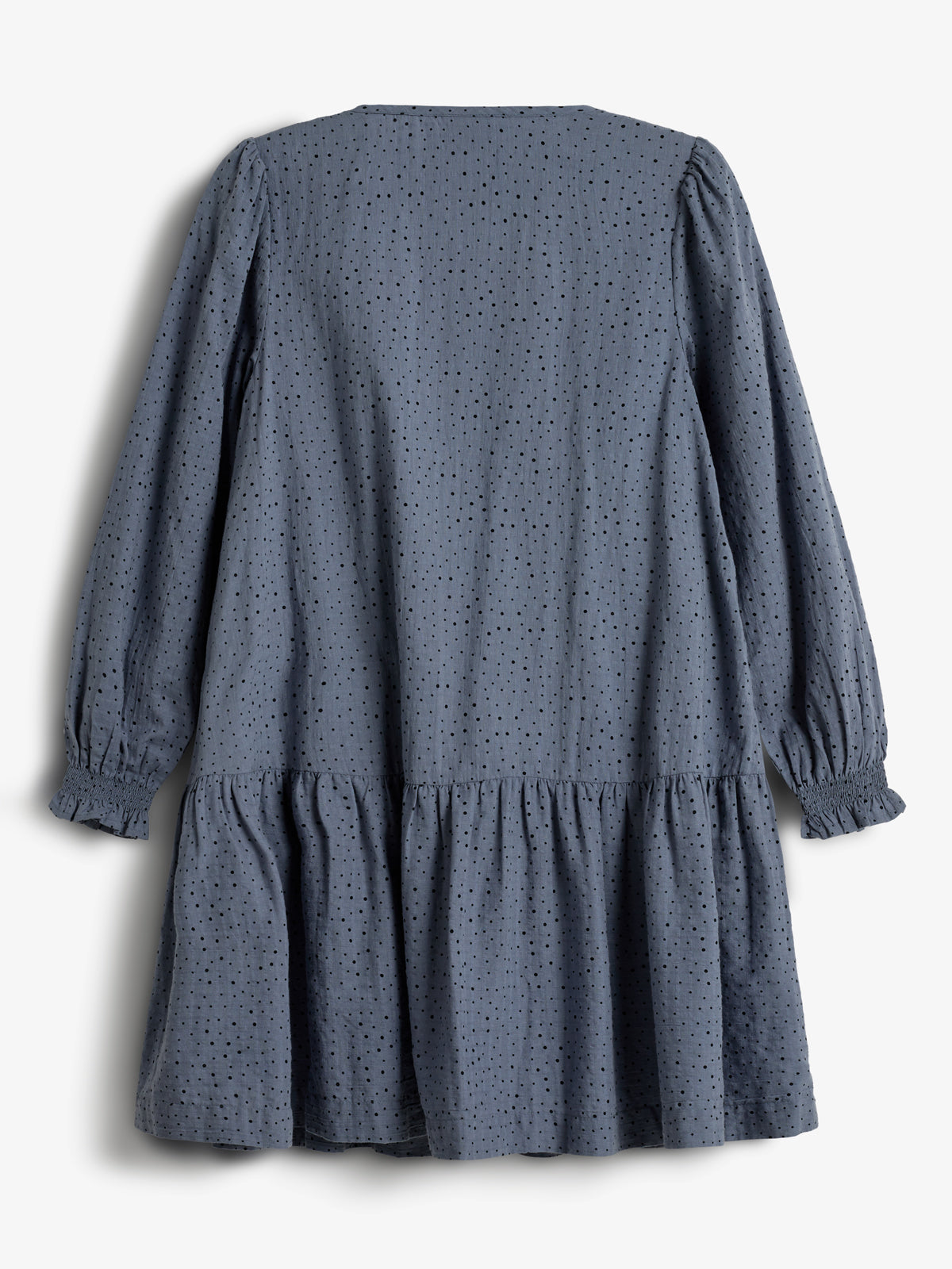 Ein langärmliges, blaues Kleid mit feinem Lochmuster hängt vertikal. Der Stoff hat leichte Raffungen an den Ärmeln und an der Taille. Hintergrund ist weiß.