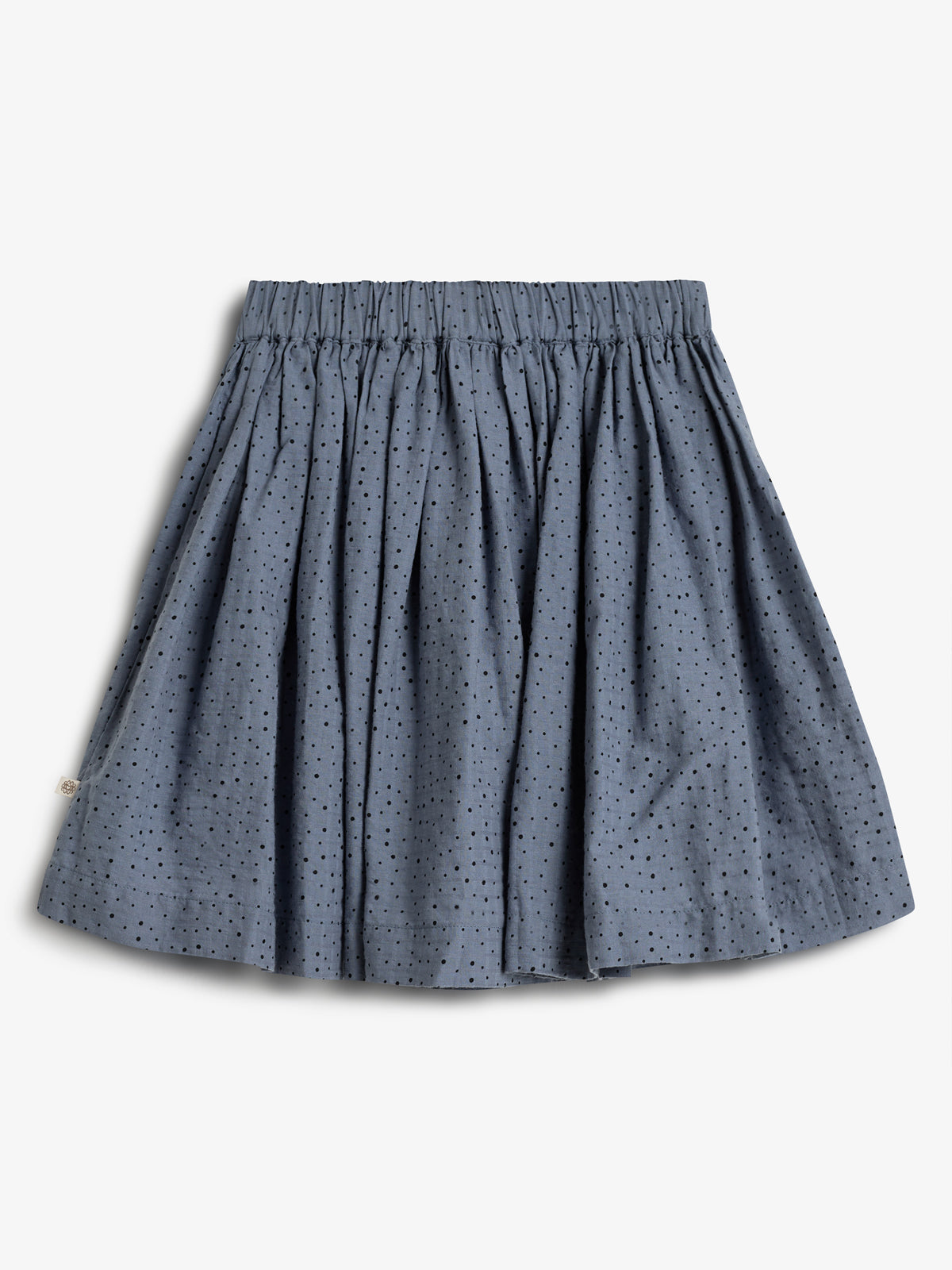 Blauer Rock mit elastischem Bund und kleinen schwarzen Punkten. Der Stoff ist locker gefaltet, präsentiert auf weißem Hintergrund.