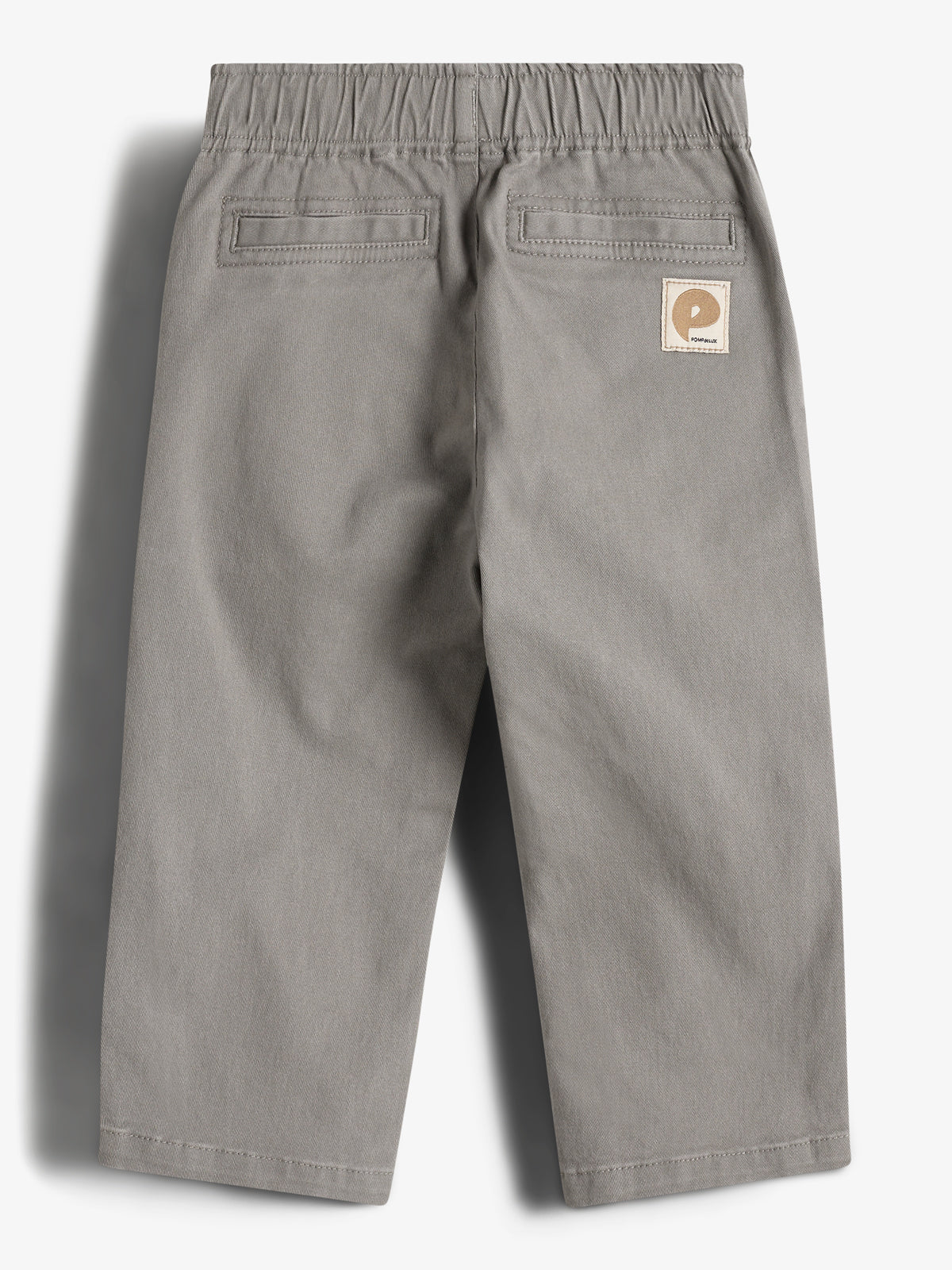 Graue Kinderhose mit elastischem Bund und zwei Gesäßtaschen, Etikett mit "Polarn O. Pyret" Logo auf der Rückseite, liegt flach vor hellem Hintergrund.