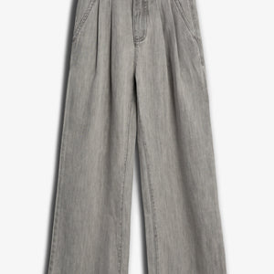 Graue, weit geschnittene Hose hängt flach auf einem weißen Hintergrund. Sie hat Bundfalten, Taschen und einen Knopfverschluss. Die Textur ähnelt Jeansstoff.