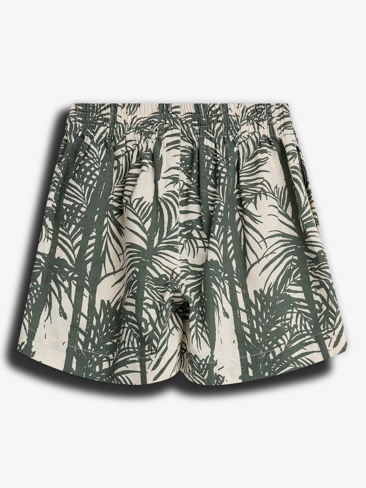 Kurze Shorts mit elastischem Bund, verziert mit einem dunkelgrünen Palmenblattmuster auf cremefarbenem Hintergrund. Die Shorts liegen flach und vermitteln einen sommerlichen, entspannten Eindruck.