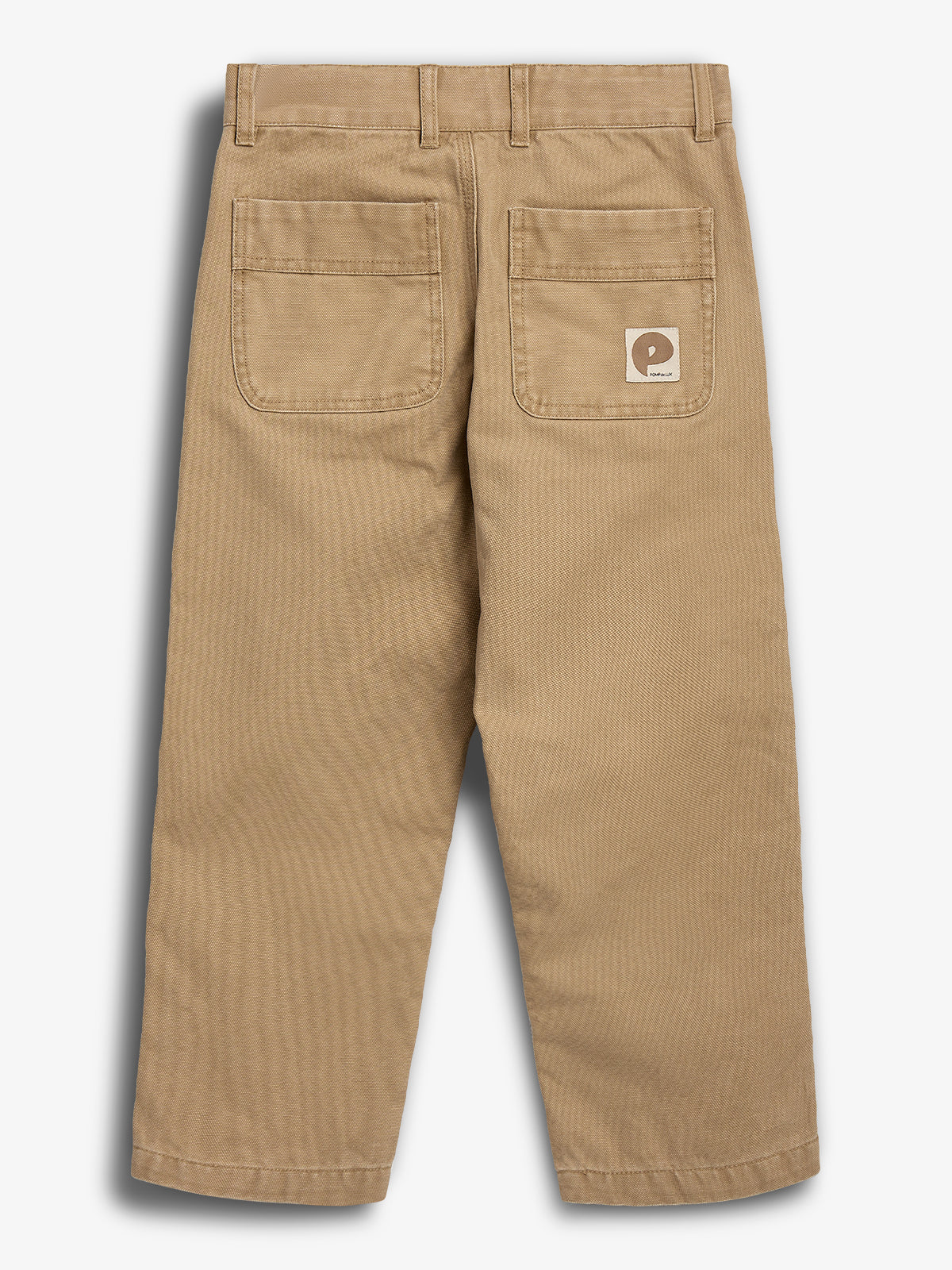 Eine beige Hose mit zwei aufgesetzten Gesäßtaschen, einschließlich eines Logos auf einer Tasche, hängt vor einem weißen Hintergrund.