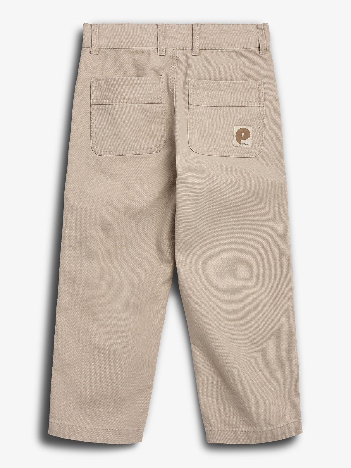 Beige Hosen mit zwei Gesäßtaschen, eine mit einem braunen „Piecemeal“-Logoetikett; sie liegen flach auf einem neutralen Hintergrund.