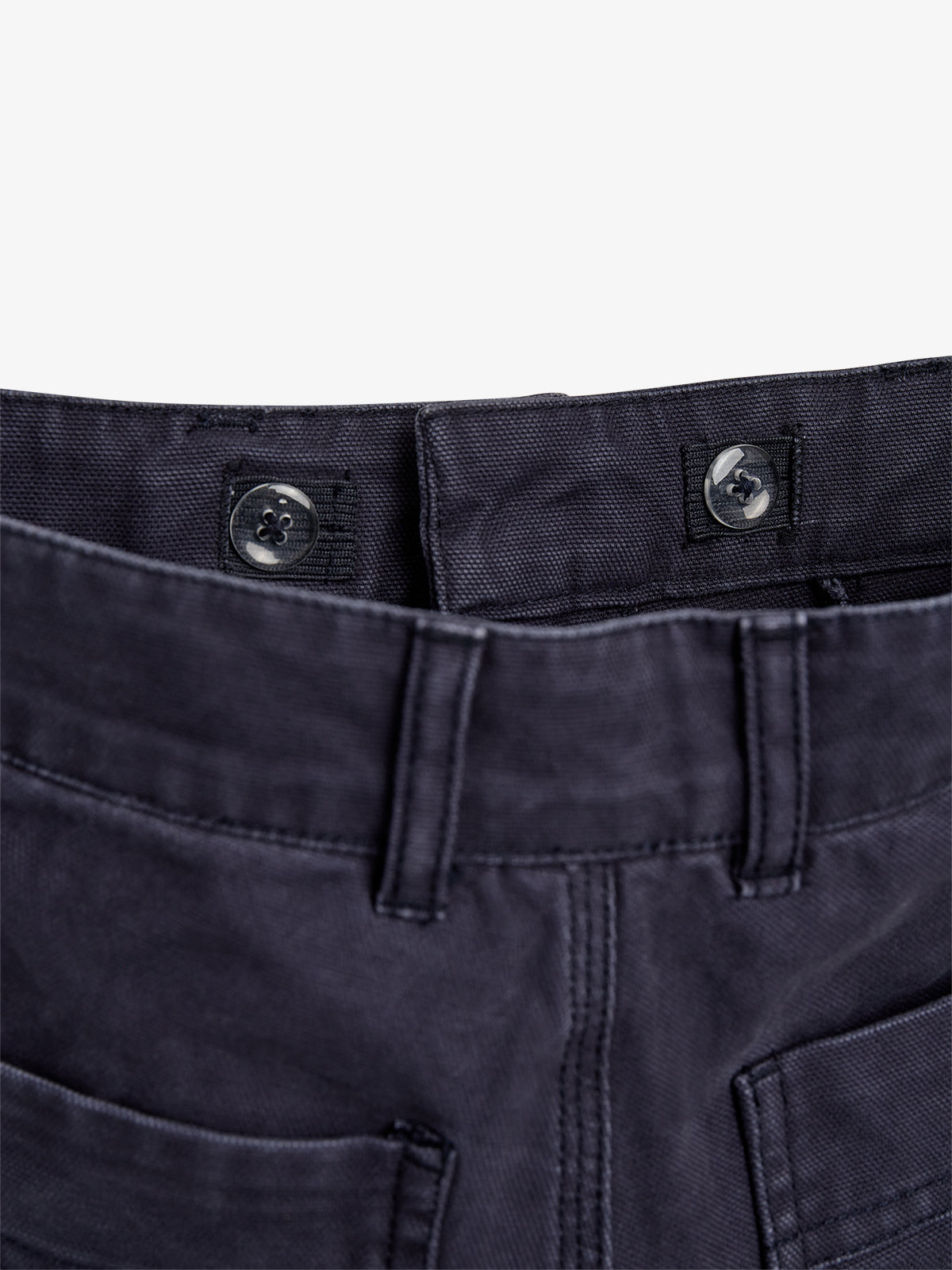 Ein dunkelblaues Hosenbund mit zwei übereinanderliegenden Knöpfen ist abgebildet. Die Hose hat Gürtelschlaufen. Der Hintergrund ist einfarbig weiß.