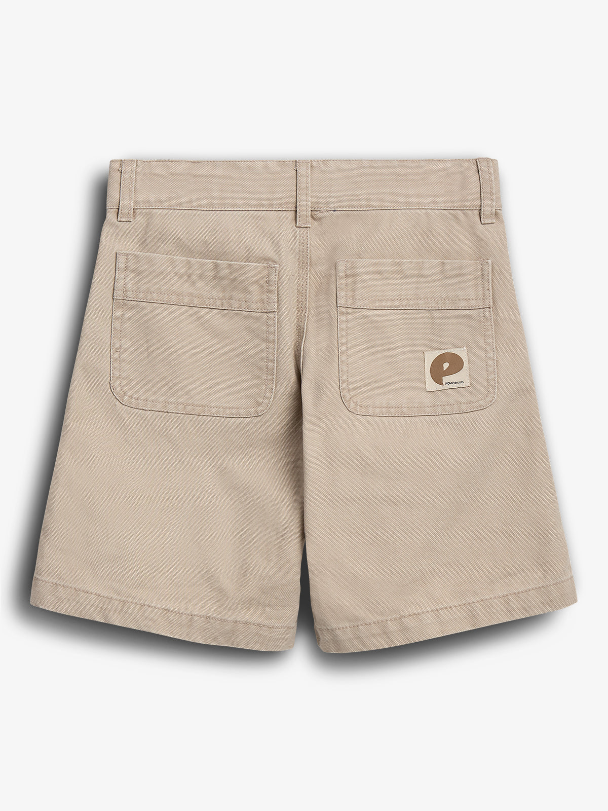 Beige Shorts mit zwei Gesäßtaschen und einem kleinen, rechteckigen Aufnäher, auf dem "POP TRADING" steht. Die Umgebung ist ein neutraler, weißer Hintergrund.