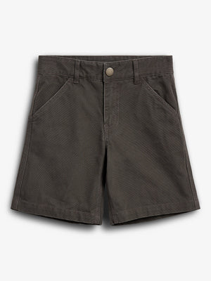 Kurze braune Hose liegt flach, mit sichtbarem Knopfverschluss und zwei Vordertaschen; einfarbiger Hintergrund betont das Kleidungsstück.