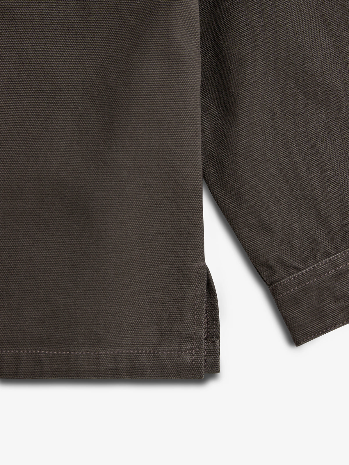 Dark brown fabric with visible texture and detailed stitching at the edge, showing a corner fold. The background is plain white, highlighting the fabric's texture and craftsmanship.