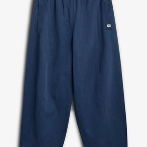 Dunkelblaue Hose mit elastischem Bund und Kordelzug, liegt flach auf weißem Hintergrund. Zwei seitliche Taschen und ein kleines Logo-Etikett an der Hüfte.