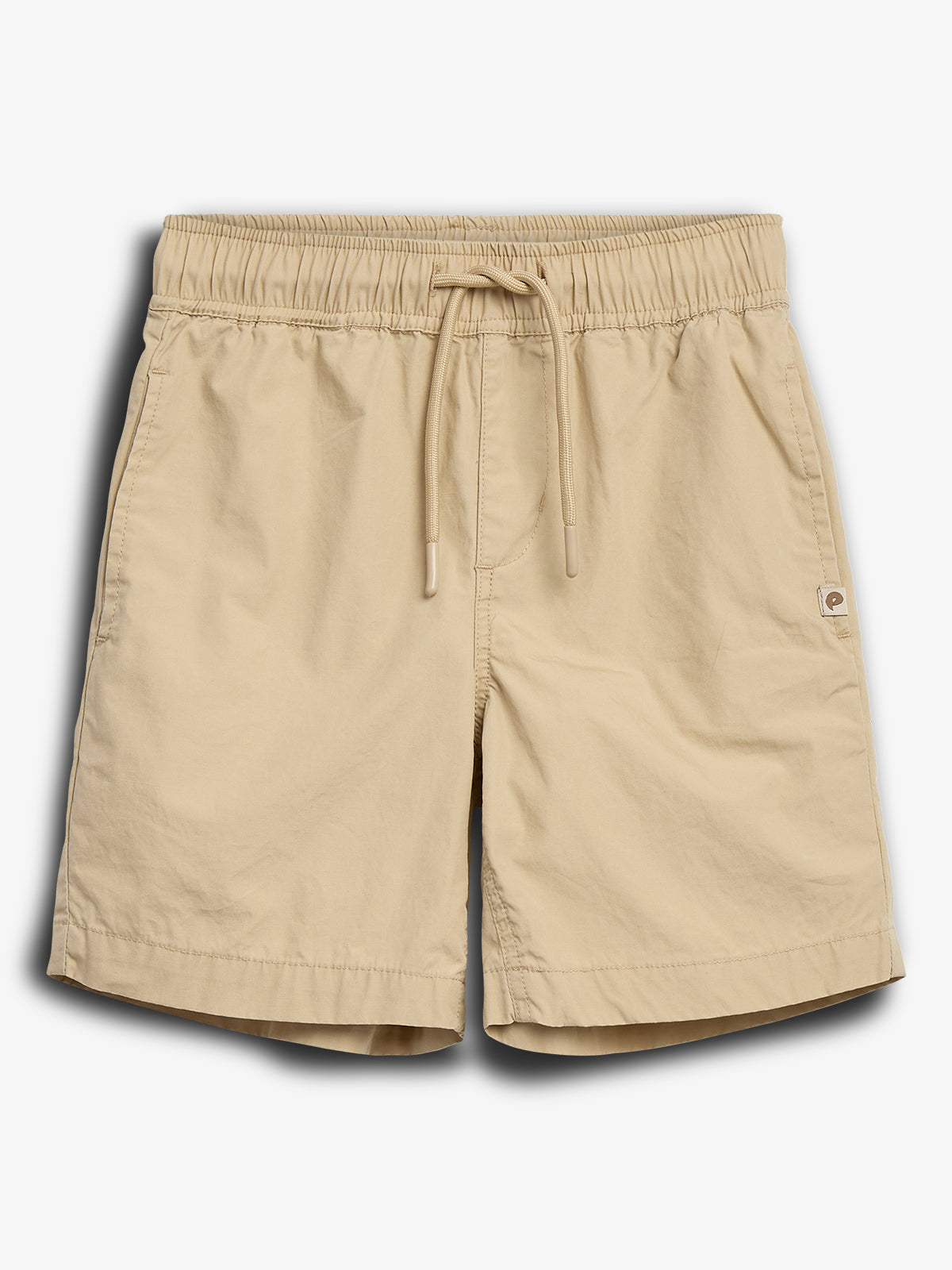Beige Shorts mit elastischem Bund und Kordelzug, Taschen an den Seiten. Das schlichte Design zeigt ein kleines Logo rechts unten. Liegt auf einem neutralen Hintergrund.