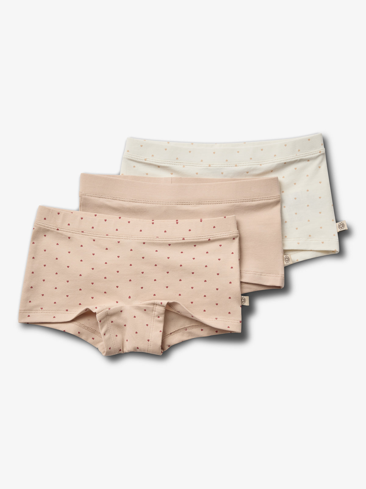 Drei Paar Damenunterhosen liegen übereinander. Beige mit roten Punkten, einfarbig beige, und creme mit beigen Punkten. Sie befinden sich auf einem einfarbigen, weißen Hintergrund.