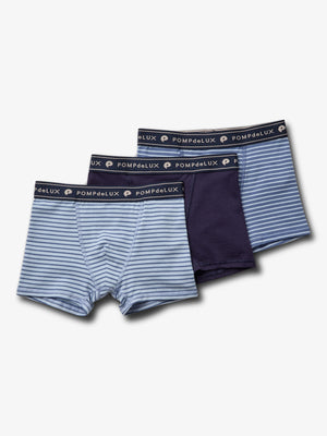 Drei Paar Boxershorts in verschiedenen Blautönen liegen nebeneinander. Zwei sind gestreift, eine ist einfarbig dunkelblau. Der Bund trägt die Aufschrift: "POMPdeLUX".