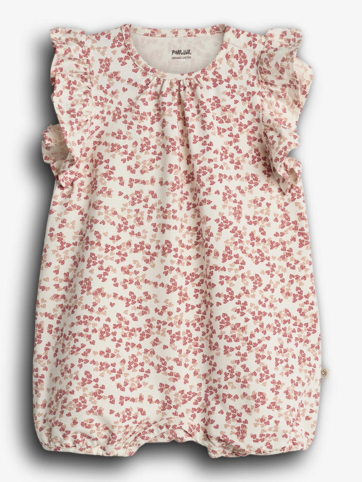 Ein Babystrampler mit rot-weißen Blümchenmuster, verziert mit Rüschen an Schultern und Ärmeln, auf weißem Hintergrund. Text auf dem Etikett: „Pehr LULI ORGANIC COTTON“.
