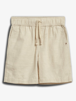 Beige Shorts mit elastischem Bund und Kordelzug, liegend präsentiert. Nebennaht-Tasche auf der rechten Seite. Hintergrund ist schlicht und hell, was das Kleidungsstück hervorhebt.