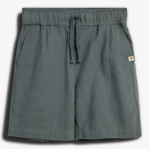Kurze, dunkelgraue Shorts mit einem Kordelzug im elastischen Bund; Design mit seitlichen Taschen und einem kleinen rechteckigen Logo auf einem Etikett am Rand. Ruhend auf weißem Hintergrund.