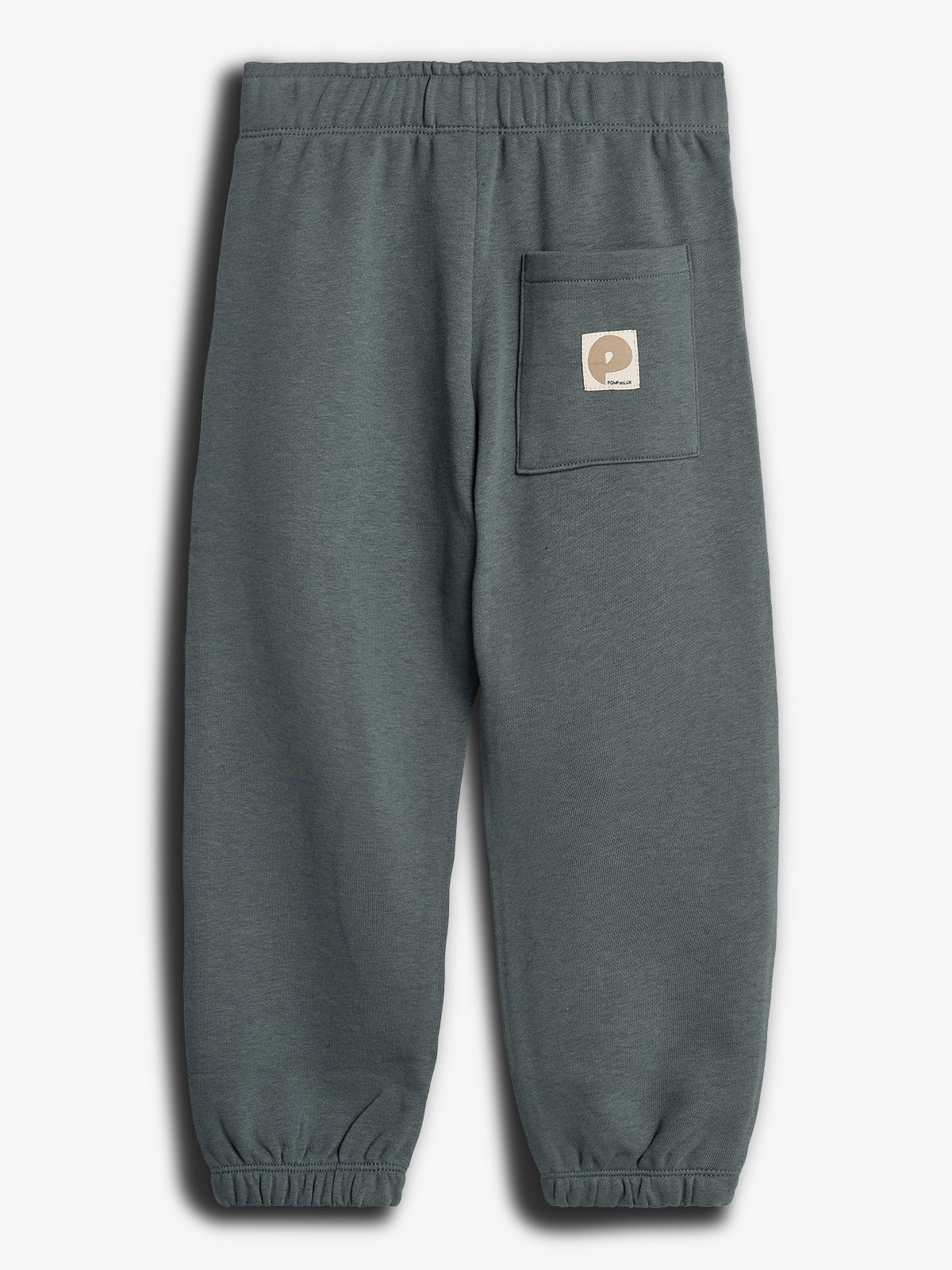 Eine graue Jogginghose mit Gummizug an Taille und Beinabschlüssen. Auf der Rückseite befindet sich eine Tasche mit einem Label mit der Aufschrift "popelin". Im Studio aufgenommen.