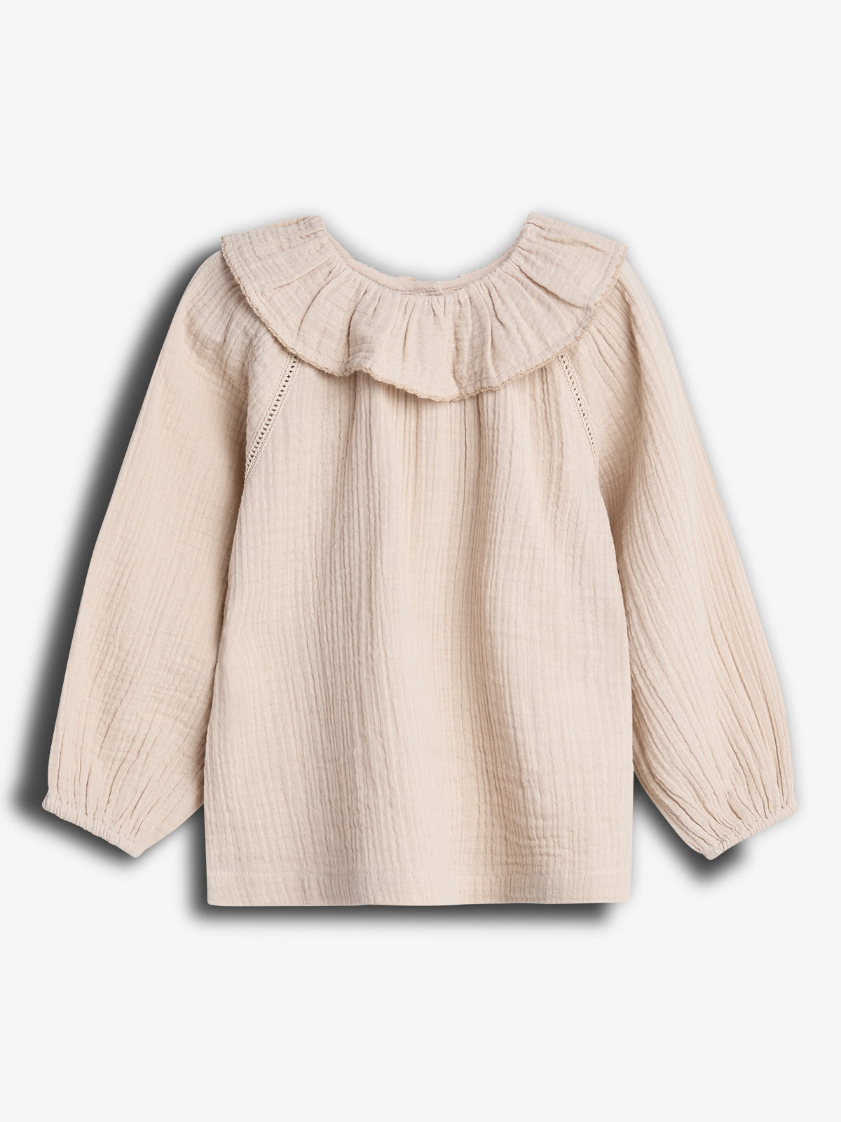 A cream-colored, long-sleeve blouse with a ruffled neckline is displayed from the back against a plain white background. The fabric appears textured and lightweight.