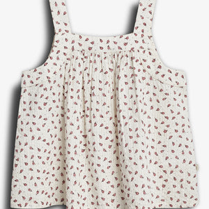 Ein ärmelloses, weißes Oberteil mit Riemen zeigt ein rotes Blumenmuster. Der Stoff fällt locker und hat eine geraffte Textur, präsentiert auf einem neutralen Hintergrund.