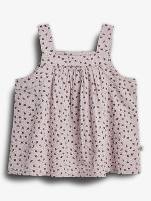 Ein rosa Sommerkleid mit breiten Trägern, verziert mit einem Muster aus kleinen braunen Blumen, hängt lose in einem neutralen, weißen Hintergrund.