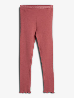 Rote Leggings hängen glatt, mit gewelltem Saum. Hintergrund ist neutral grau, was die Textur und Farbe der Leggings hervorhebt.