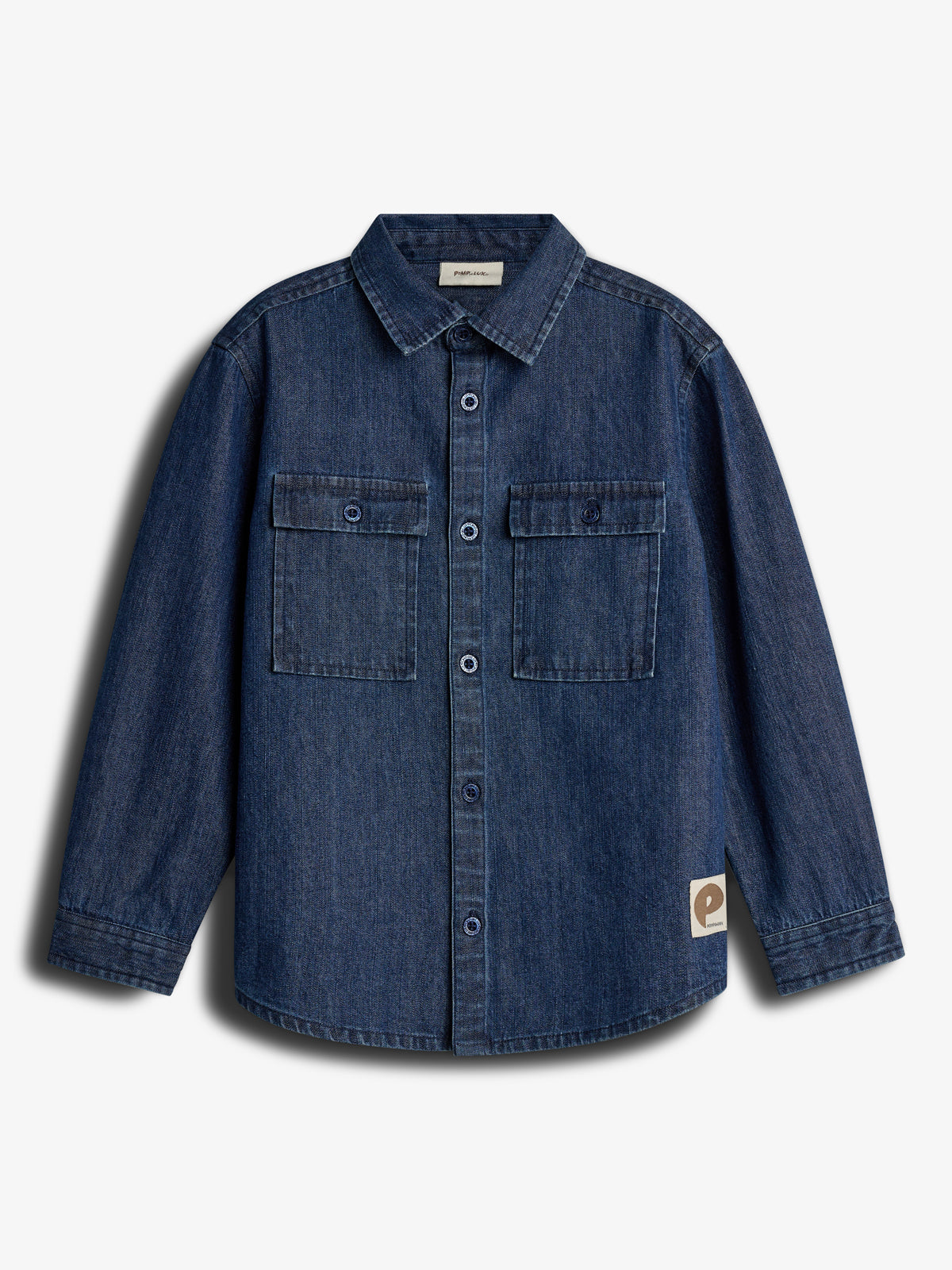 Dunkelblaue Jeansjacke mit Knopfleiste und zwei Brusttaschen, hängt still vor weißem Hintergrund. Ein rechteckiges Etikett mit einem „e“ ist unten rechts angenäht.