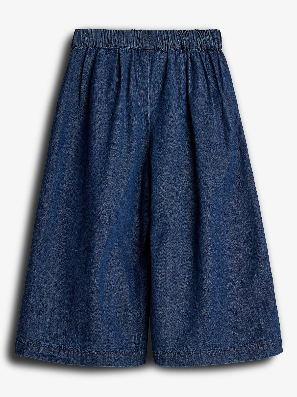 Eine dunkelblaue Culotte-Hose mit elastischem Bund hängt ohne Falten in einem gut beleuchteten Studio.