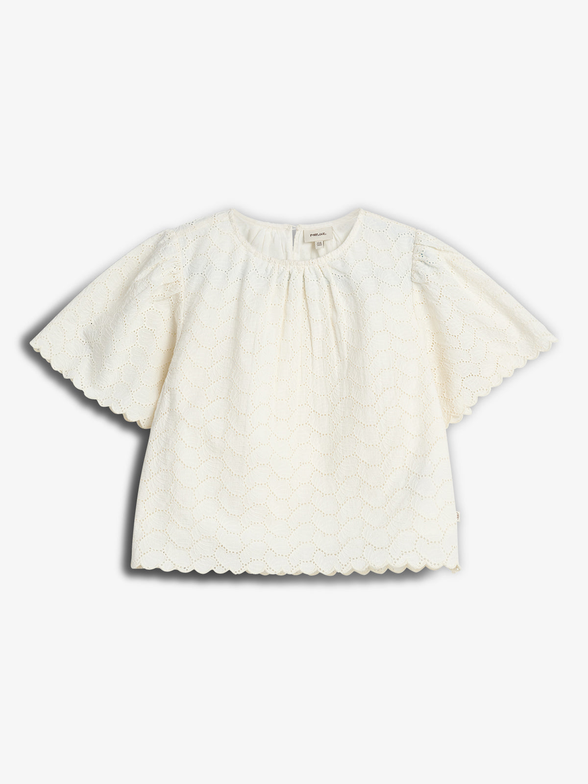 Weiße Kinderbluse mit rundem Ausschnitt und kurzen, wellenförmig gesäumten Ärmeln. Spitzendetails bedecken den Stoff. Liegt flach auf weißem Hintergrund.