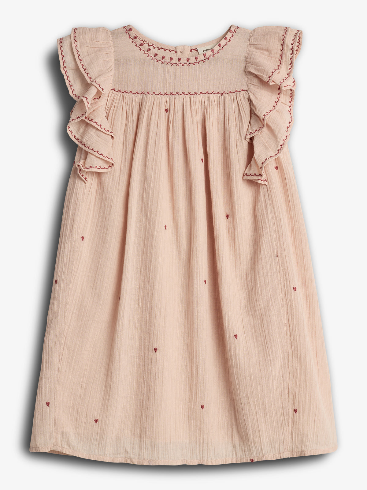 Ein rosa Kinderkleid mit roten Stickereien und Herzmustern ziert die ausgestellten Schultern. Es hängt vor einem neutralen, weißen Hintergrund.
