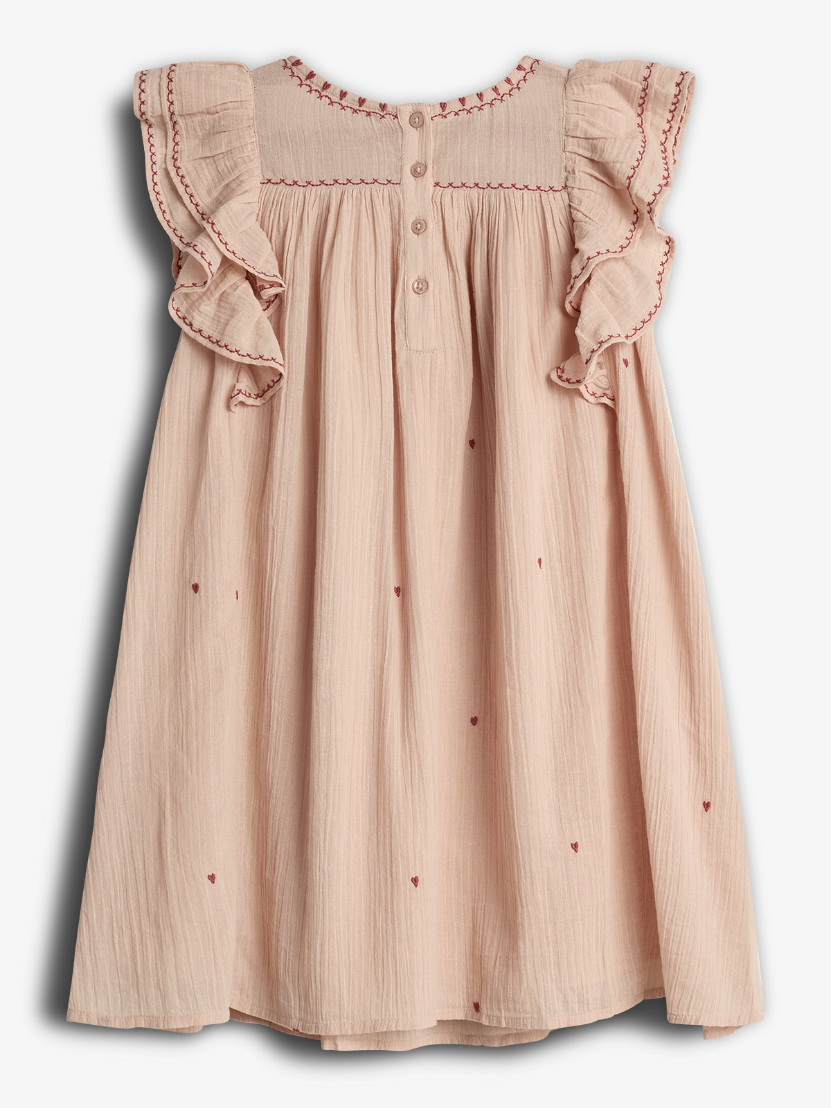 Ein cremefarbenes Kinderkleid mit rot bestickten Rüschenärmeln und kleinen aufgestickten Herzmotiven, hängt vor einem neutralen Hintergrund hängt. Drei Knöpfe zieren die Rückseite.