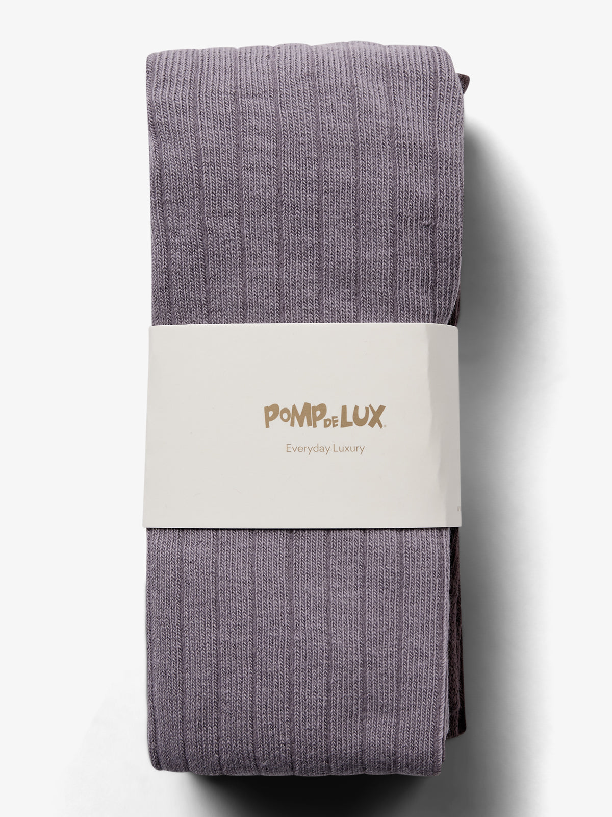 Ein Paar lilafarbene Strumpfhosen, ordentlich gefaltet, ruht auf einem weißen Hintergrund. Ein weißer Papierstreifen hält sie zusammen mit der Aufschrift "POMPdeLUX Everyday Luxury".