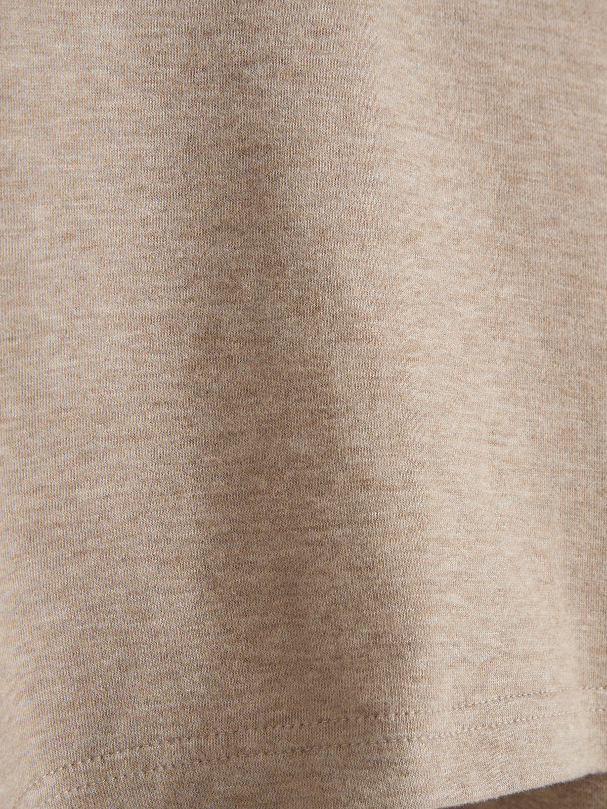Beigefarbener Stoff zeigt eine gleichmäßige Webstruktur, ohne Muster oder Text. Der Bildausschnitt fokussiert sich auf die Beschaffenheit und Textur des Materials.