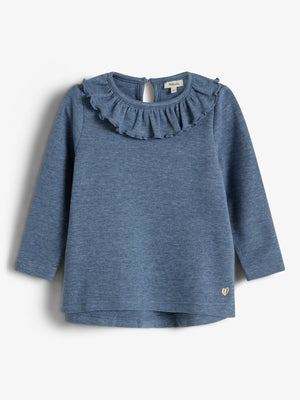 Der Pullover hat lange Ärmel und einen gewellten Kragen. Er besteht aus blauem Stoff. Im unteren Bereich befindet sich ein kleines goldenes Herzsymbol. Hintergrund ist schlicht weiß.