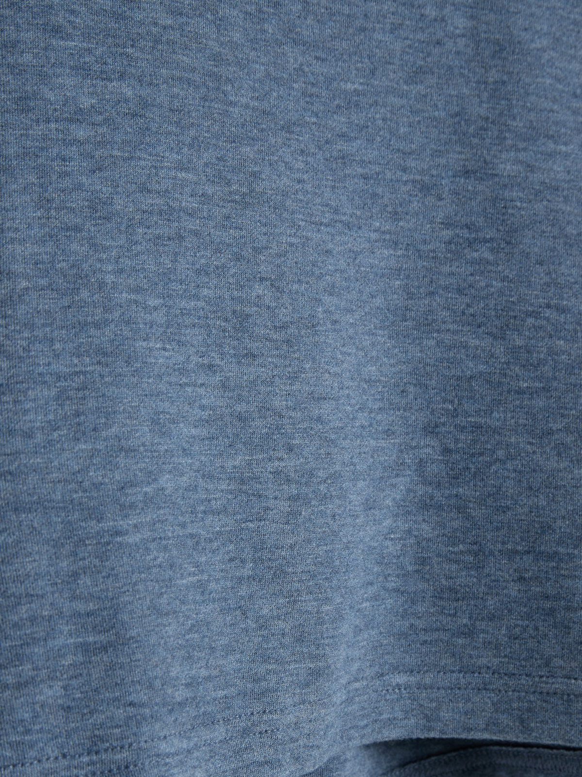 Stoffgewebe hängt ruhig, zeigt eine gleichmäßige blaue Textur mit feiner Struktur. Keine weiteren Objekte oder Texte vorhanden; der Fokus liegt auf dem Material und seinem Erscheinungsbild.