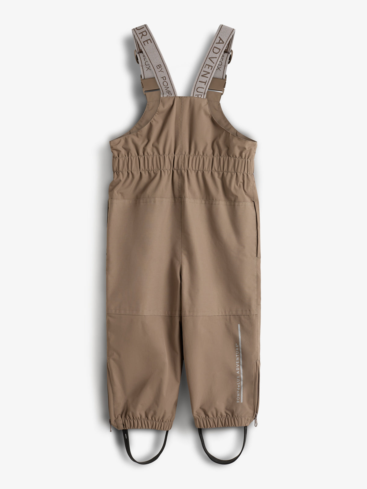 Beige Kinder-Latzhose mit elastischen Hosenträgern und Aufdruck „ADVENTURE“ im Innenbereich. Sie verfügt über elastische Bündchen und Fußschlaufen, ideal für Outdoor-Aktivitäten.