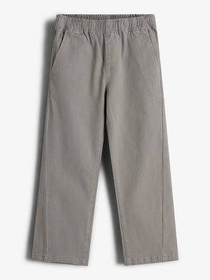 Graue, weite Hose mit elastischem Bund liegt flach auf einem weißen Hintergrund. Sie hat zwei seitliche Taschen und besteht aus einem leichten Stoff, geeignet für legere Anlässe.