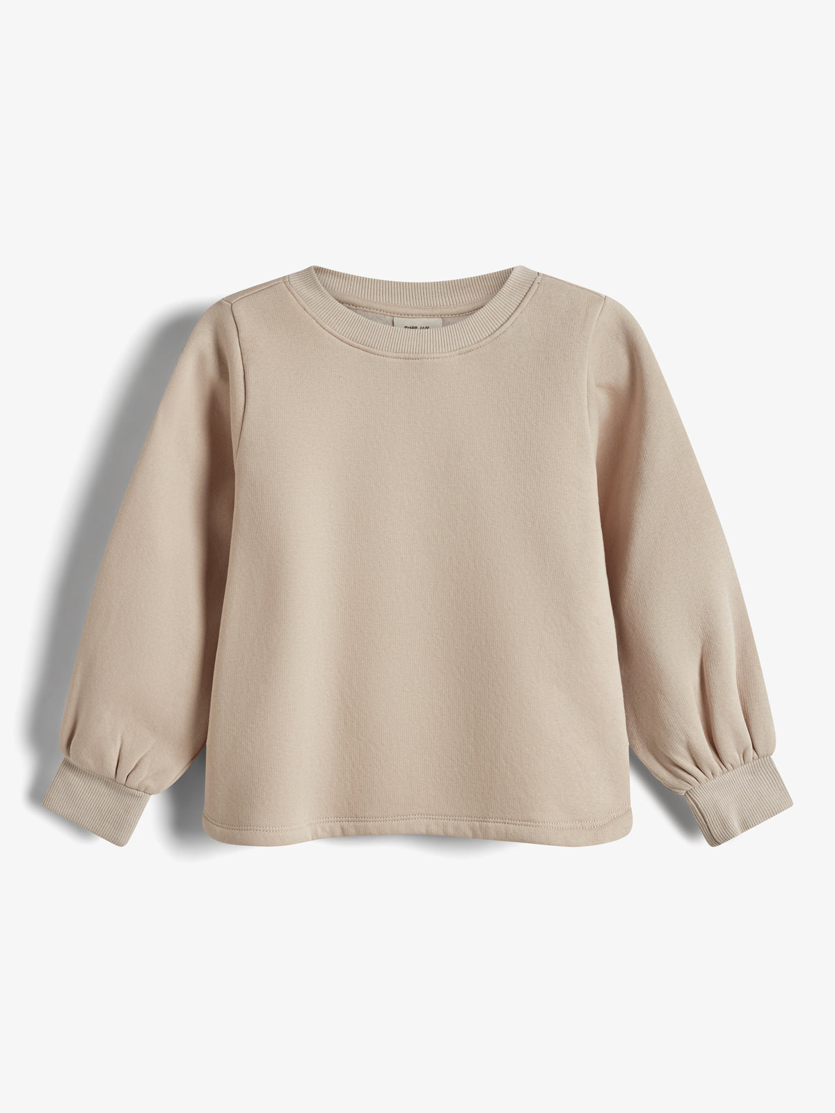 Ein beiges Sweatshirt mit langen Ärmeln und gerippten Bündchen hängt vor einem neutralen Hintergrund.