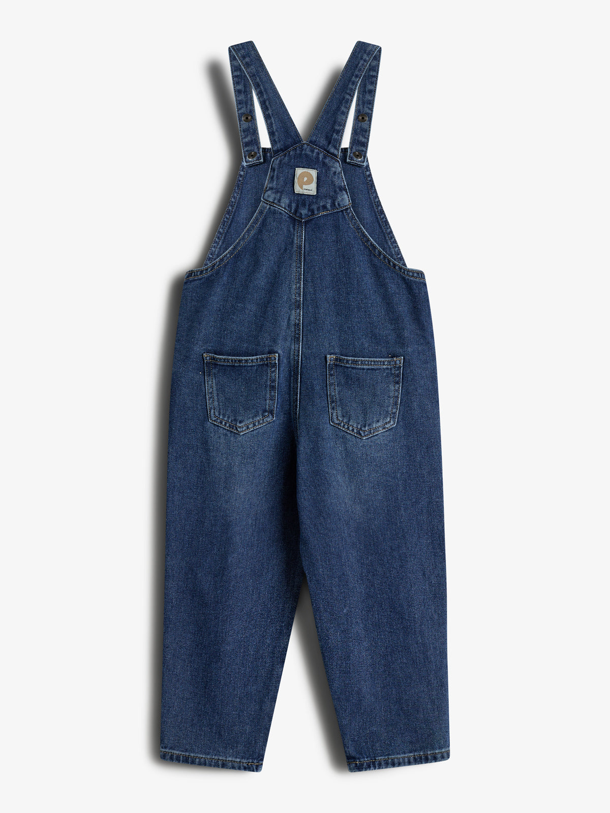 Eine blaue Jeans-Latzhose hängt flach auf einem weißen Hintergrund. Sie hat zwei Taschen vorne und ein Markenetikett mit einem stilisierten Pferdekopf in der Mitte.
