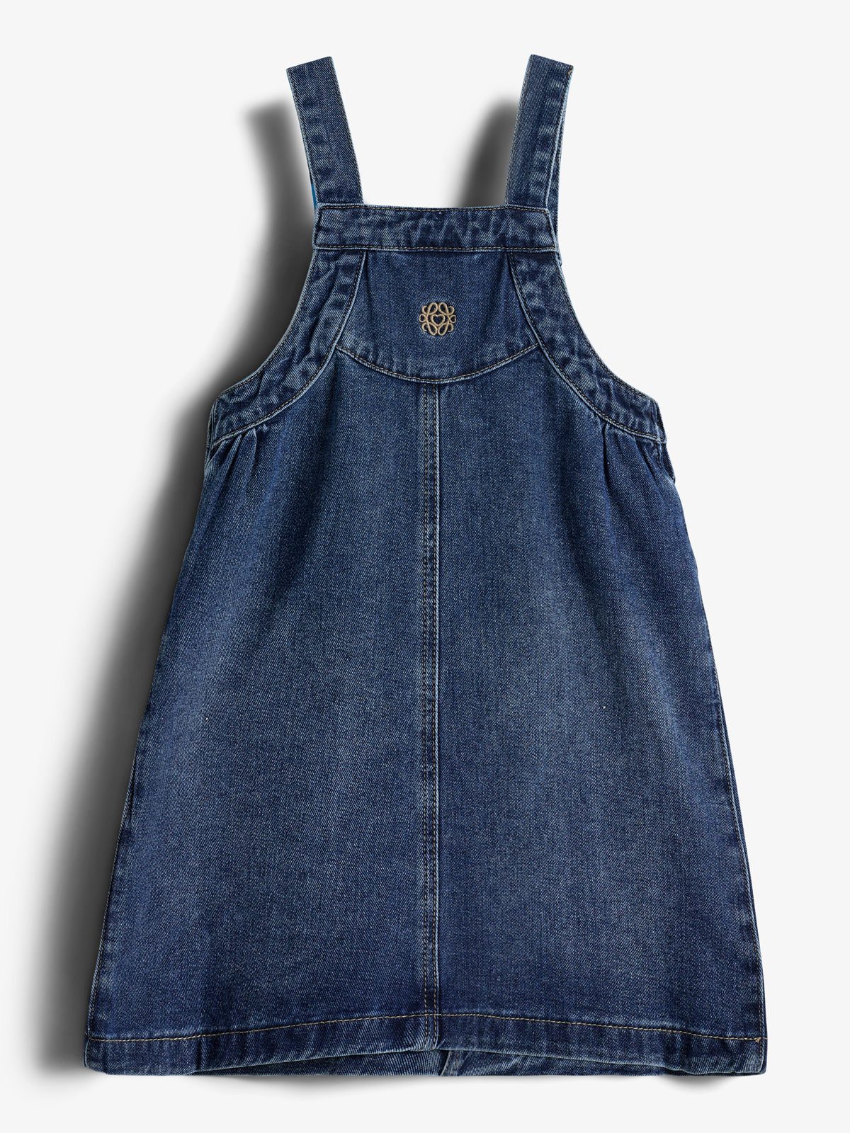 Jeanskleid mit Trägern, hängt flach vor einem weißen Hintergrund. Das gestickte Symbol befindet sich auf der Brust.