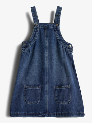 Jeanskleid mit zwei Trägern, Knöpfen und aufgesetzten Taschen, liegt flach auf einem weißen Hintergrund.