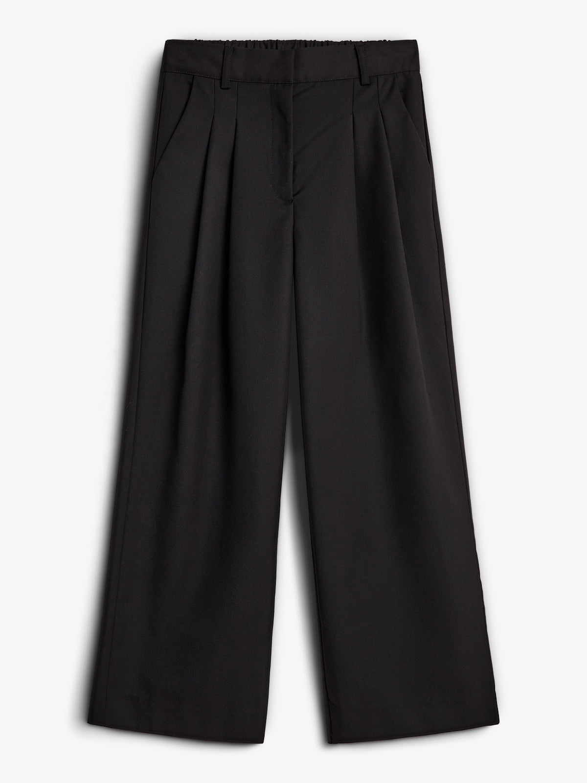 Schwarze, weit geschnittene Hose hängt flach und ungetragen. Sie hat Falten vorne und einen elastischen Bund. Der Hintergrund ist einfarbig weiß.