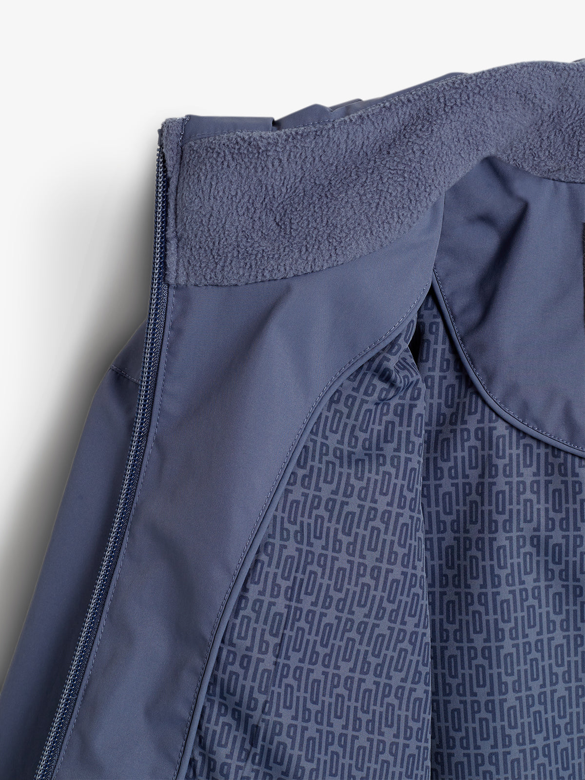 Eine dunkelblaue Jacke zeigt eine geöffnete Ansicht; innen ein weiches Futter und mit kleinen, wiederholten "POP"-Buchstaben bedruckt. Der Hintergrund ist weiß.